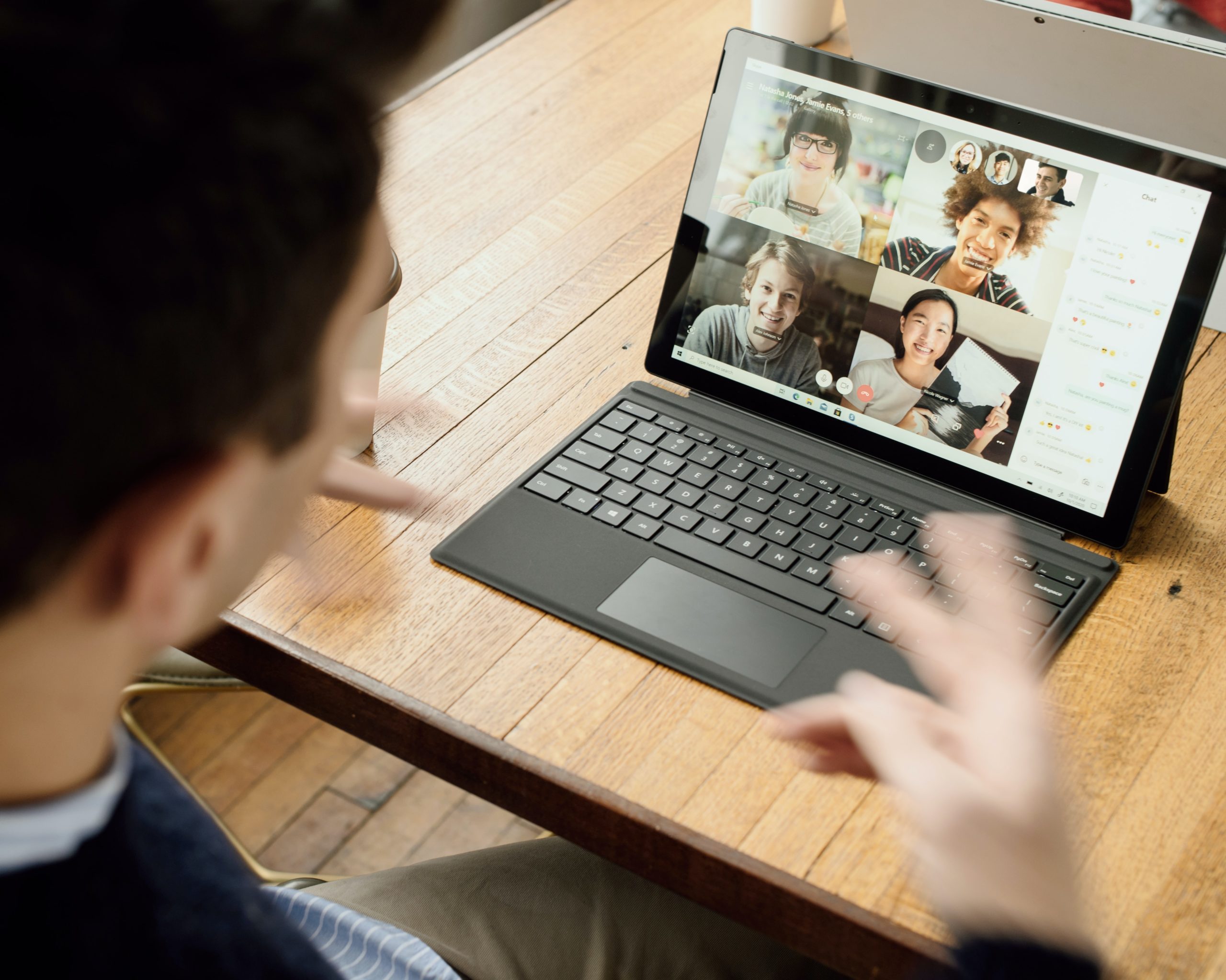 Man on laptop speaking on a conference call to four diverse colleagues